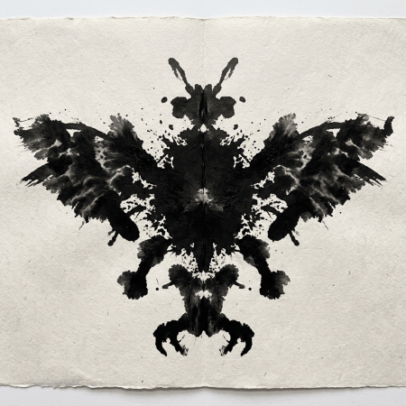 Symmetrical black inkblot resembling an eagle with outstretched wings